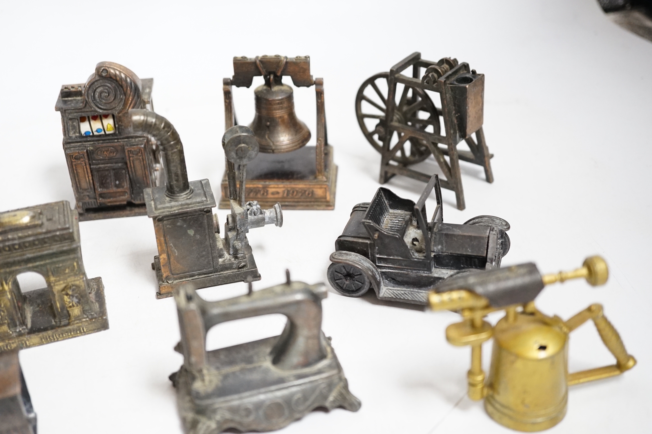A collection of novelty metal pencil sharpeners and a pair of late Georgian silver plated candlesticks, 20cm